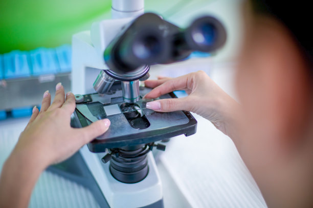 女科学家在实验室里研究和观察显微镜。图片下载