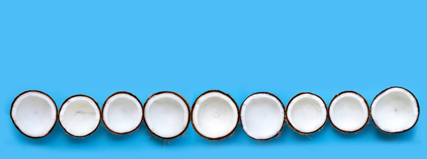 一半椰子在蓝色的背景。图片下载