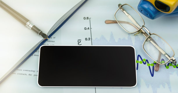 黑色智能手机的黑屏模型躺在纸上，上面有彩色图表图片下载