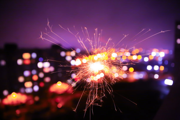 模糊的夜晚城市灯光照片与孟加拉火。抽象节日假日背景中的散景效果。图片下载