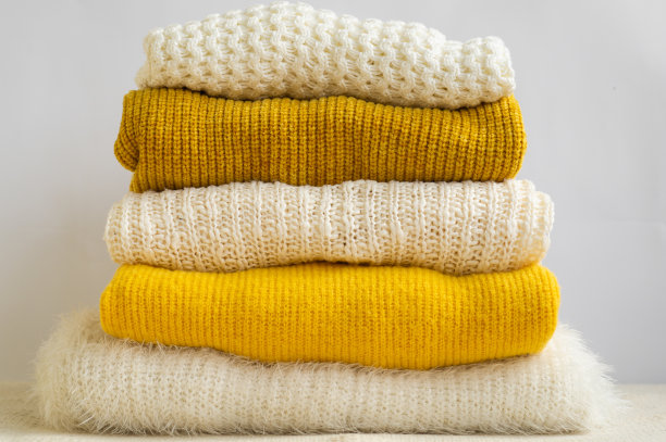 针织衣服堆黄白色。秋冬的概念。图片下载