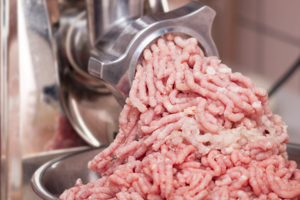 特写切碎的猪肉和洋葱从绞肉机出来。图片下载