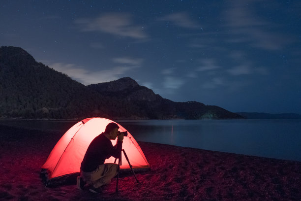 在海滩上露营的摄影师。图片下载