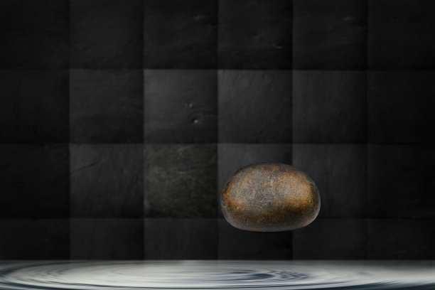 浮在水面半空中的光滑石头图片下载