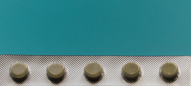 蓝色背景上带圆形药片的银色水泡的一部分。关闭了。文本的空闲空间图片下载