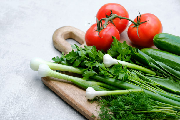 切菜板上的新鲜沙拉原料。俯视图有机蔬菜红番茄，黄瓜，欧芹和大葱。节食食物，素食菜单概念。图片下载