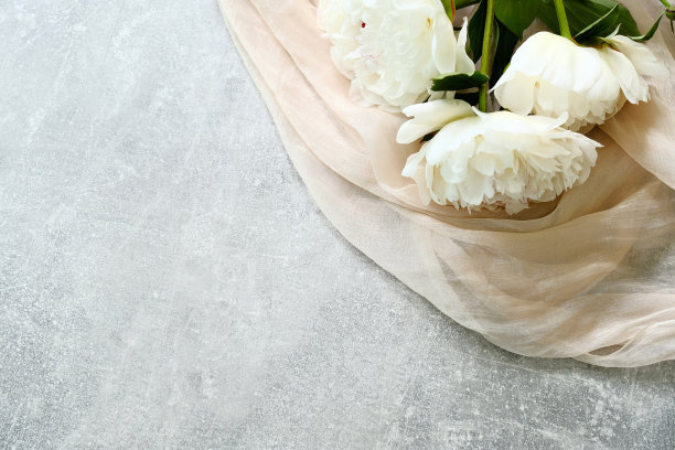 混凝土桌上摆着一束牡丹花和米色织物，从上面俯瞰。母亲节，妇女节，婚礼庆祝概念。图片下载