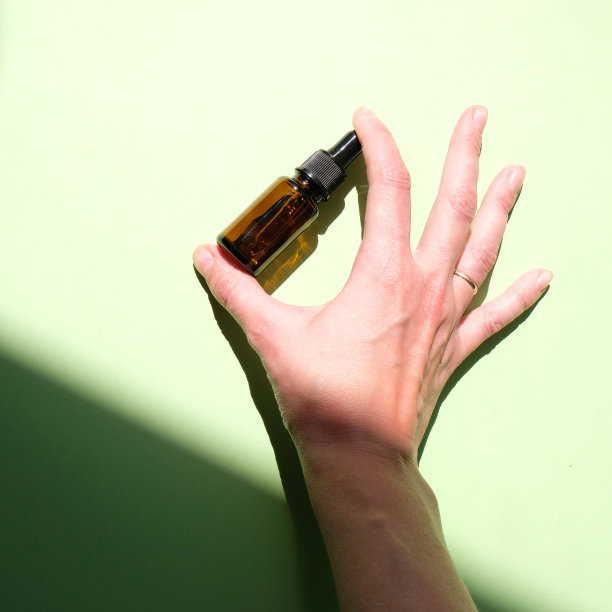 绿色背景上，手里拿着一瓶精油图片下载