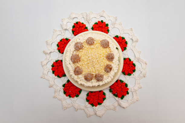 巧克力蛋糕上覆盖着磨碎的白巧克力。在一条花织毛巾上面。孤立在白色背景上。前视图。水平射图片下载