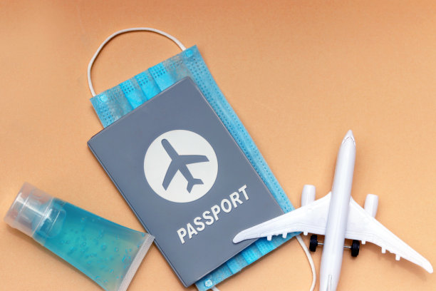 护照，带医用口罩，洗手液，飞机，淡珊瑚色背景，有拷贝空间。图片下载