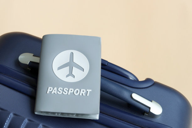 护照放在蓝色行李箱上，奶油色背景，有复印空间。图片下载