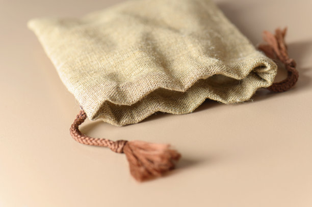 一个带绳结的小粗麻布帆布包。乡村风格的礼物。图片下载