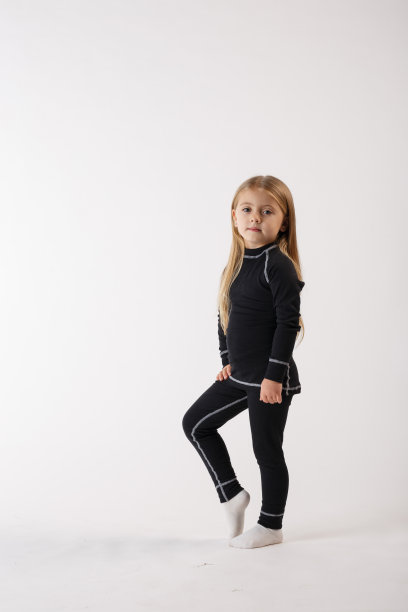 白色背景下穿着保暖内衣的小女孩。运动服装。图片下载