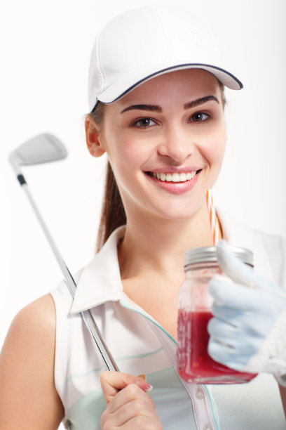 漂亮的高尔夫姑娘在工作室里拿着一罐排毒果汁图片下载