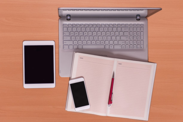 新技术桌上:打开笔记本电脑、手机、平板电脑和用红笔打开笔记本电脑图片下载