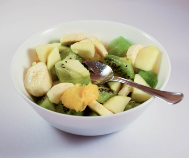 白色背景上的一碗健康的新鲜水果沙拉。图片下载