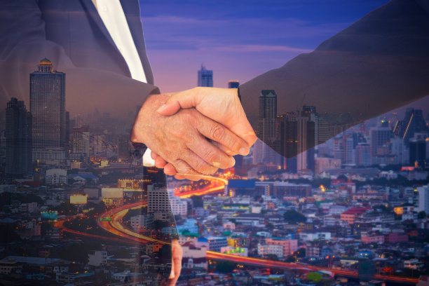 承诺与商人和都市背景握手双重曝光图片下载