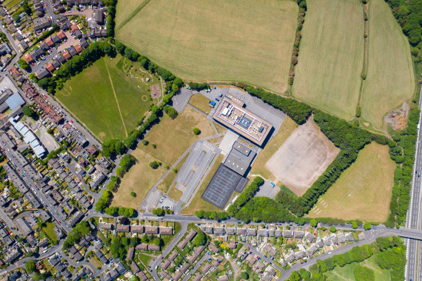 从上到下的无人机拍摄的惠特克利夫山小学，这是一个阳光明媚的夏日里英国学校和居民住宅的航拍照片图片下载