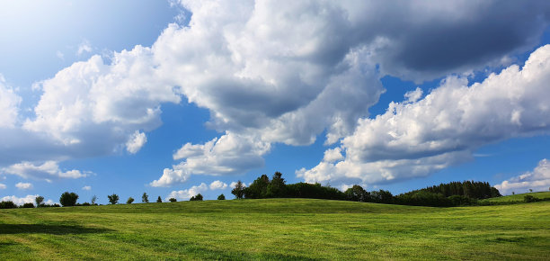 夏季草地景观与白云的背景。图片下载