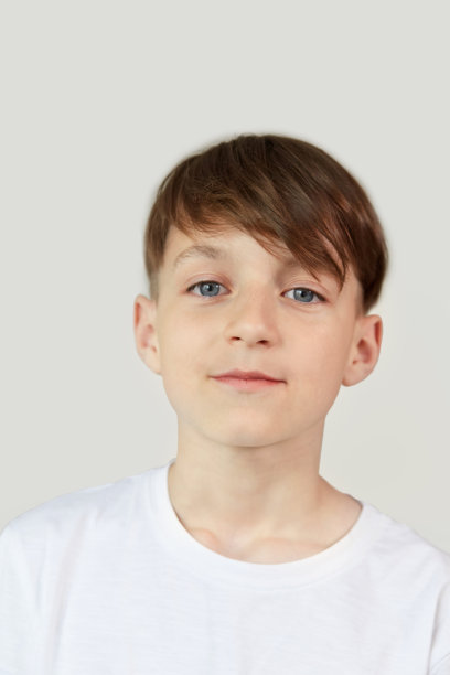 这个可爱的男孩看起来像个白人，深色头发看着镜头。图片下载
