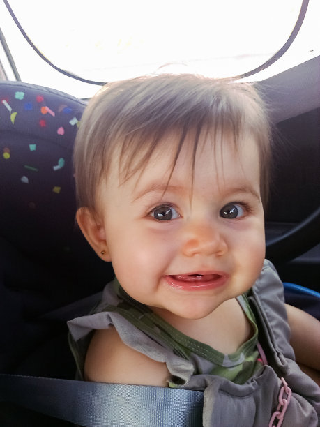 快乐可爱的小婴儿在她的汽车座椅上图片下载