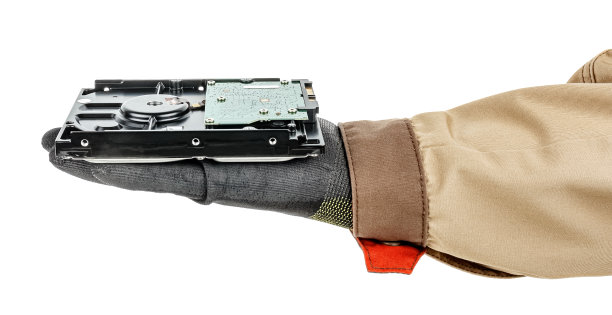 电脑硬盘戴着黑色防护手套，放在人的手掌上，棕色的制服孤立在白色的背景上图片下载