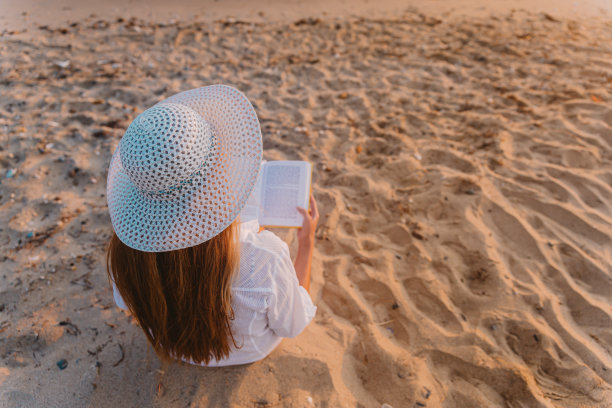 在海滩上看书的女人图片下载