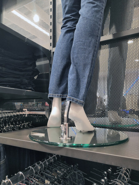 商店里穿着各种牛仔裤的模特腿的彩色照片。图片下载