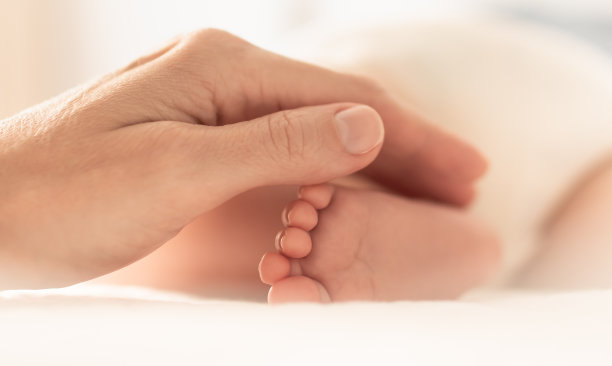 婴儿的脚在妈妈的手里。图片下载