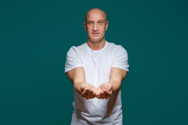秃头男子微笑着把手放在面前，手心朝上，背景是蓝色的图片下载