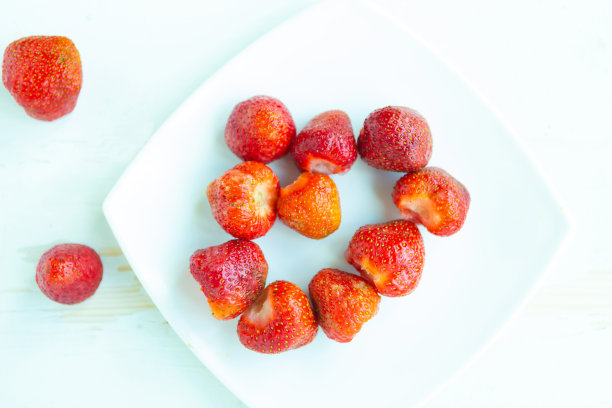 新鲜美味的草莓放在白色盘子上，俯视图图片下载