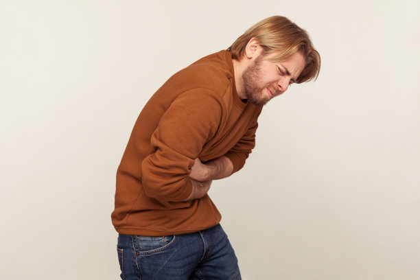 中毒,腹部痉挛。一幅生病的大胡子男人的肖像，因为强烈的胃痛而弯腰驼背图片下载