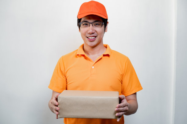 兴高采烈的快递员拿着纸板箱。图片下载