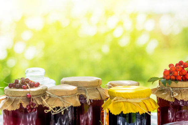 玻璃罐里的水果和浆果，白木桌上放着生草莓、樱桃、花楸和红醋栗图片下载