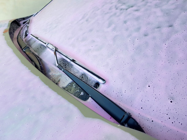 挡风玻璃用雨刷涂上一层活性洗涤泡沫用于洗车，近景侧视图无人。图片下载