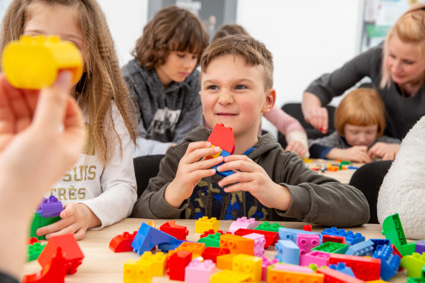 可爱的孩子在教室玩玩具积木建筑形状-库存照片图片下载