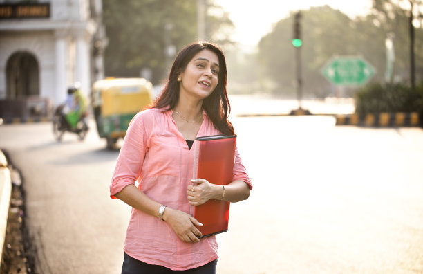女商人在城市里叫出租车图片下载