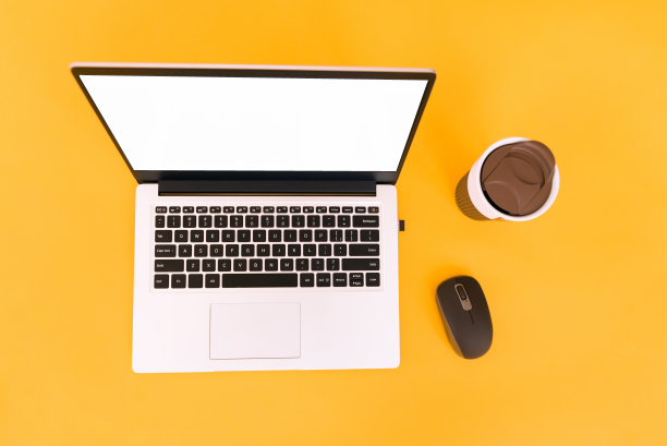 顶视图的业务工作场所与热杯咖啡，空的工作空间和鼠标在黄色的桌子背景。在笔记本电脑上复制空间。图片下载