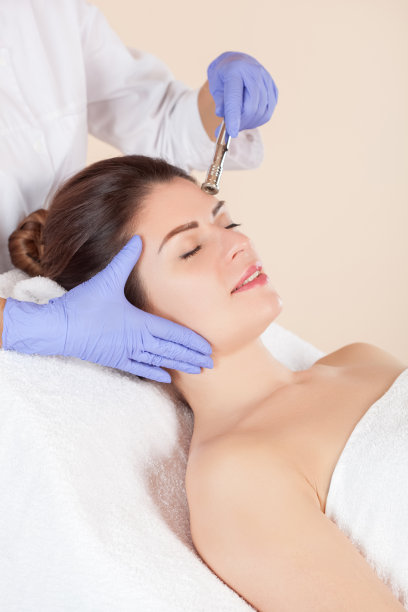 在美容院对一位美女的面部皮肤进行微晶磨皮术。美容和专业皮肤护理。图片下载