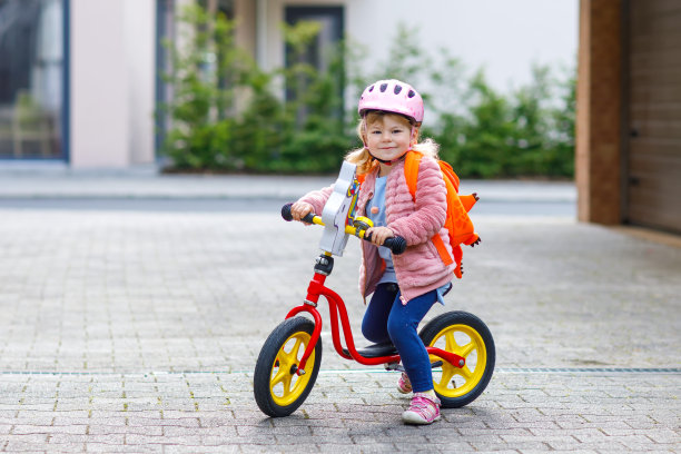 快乐的学步小女孩第一天去幼儿园。健康的婴儿推着自行车去幼儿园。从冠状病毒和covid - 19大流行疾病隔离后返回幼儿园图片下载