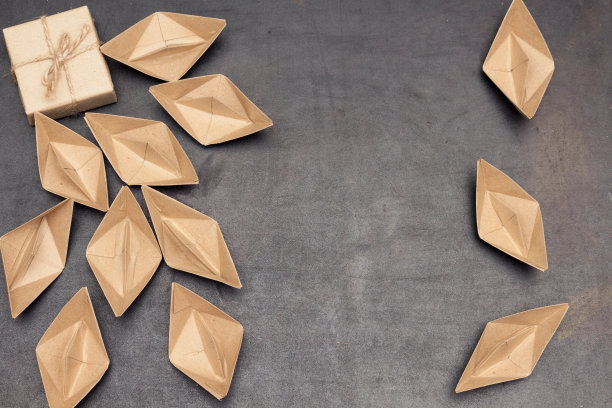 铅磁石或礼品订户吸引纸船(人)。黑色背景，平铺，复制空间。图片下载