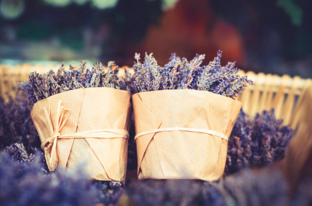两束薰衣草花放在一个篮子里，用棕色牛皮纸包好，用绳子绑好图片下载