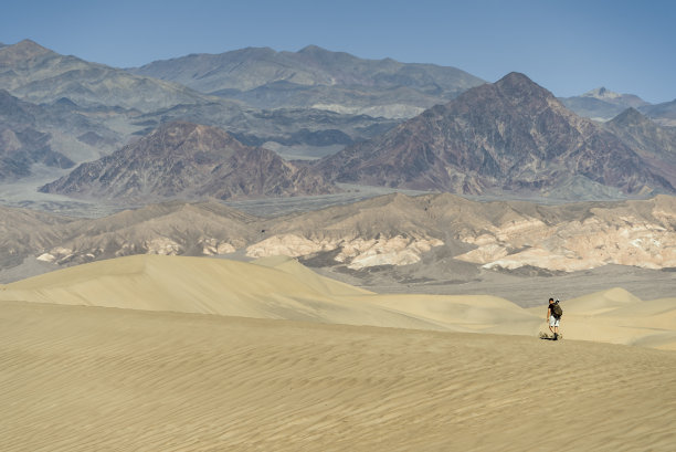 男性徒步旅行者和摄影师徒步在死亡谷沙丘加利福尼亚图片下载