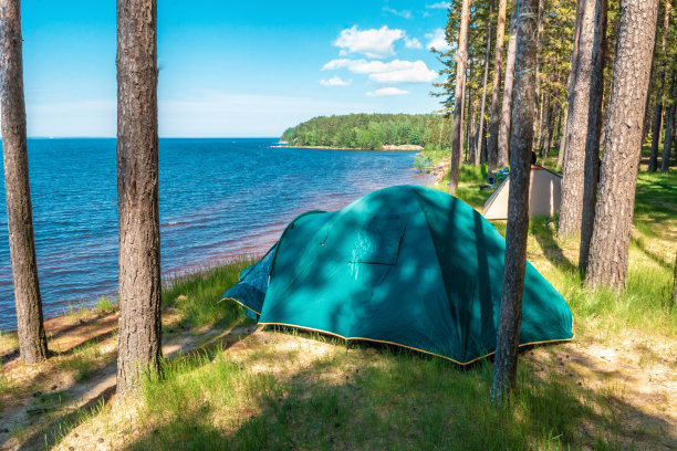游客帐篷搭在高高的湖岸上，风景优美，夏日阳光灿烂图片下载