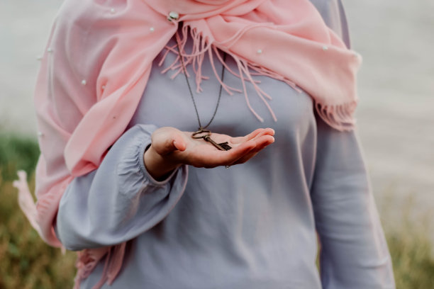 那个围着围巾的女孩拿着一条项链，手里拿着一把钥匙图片下载