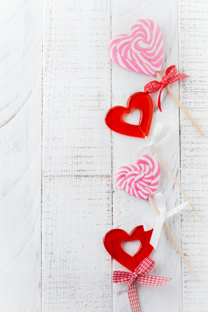 一组喜庆的心形糖果，以白色木质为背景。有选择性的重点。的情人节卡片。前视图。文本。图片下载