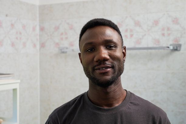 一名年轻黑人男子在浴室里看镜头的肖像图片下载