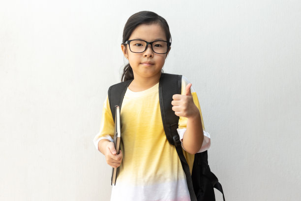 亚洲女孩小学与书和包。回到学校。教育的概念图片下载