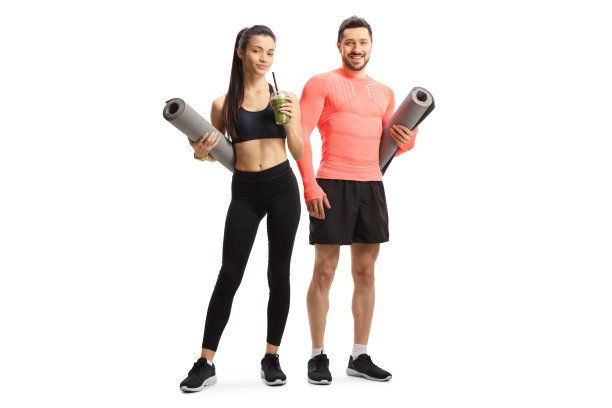 一个穿着运动服拿着运动垫的健康男子和一个喝着绿色奶昔的年轻女子图片下载