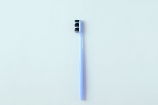 白色背景下的黑色刷毛的蓝色牙刷。图片下载